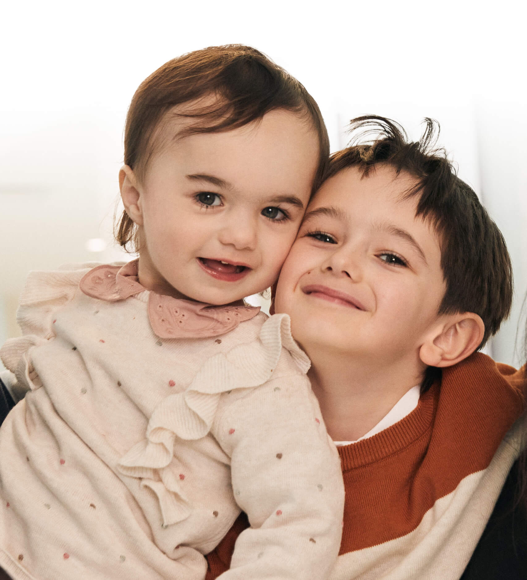 Viviane, une jeune patiente de deux ans, est enlacée par son grand frère Édouard, tout sourire à ses côtés.
