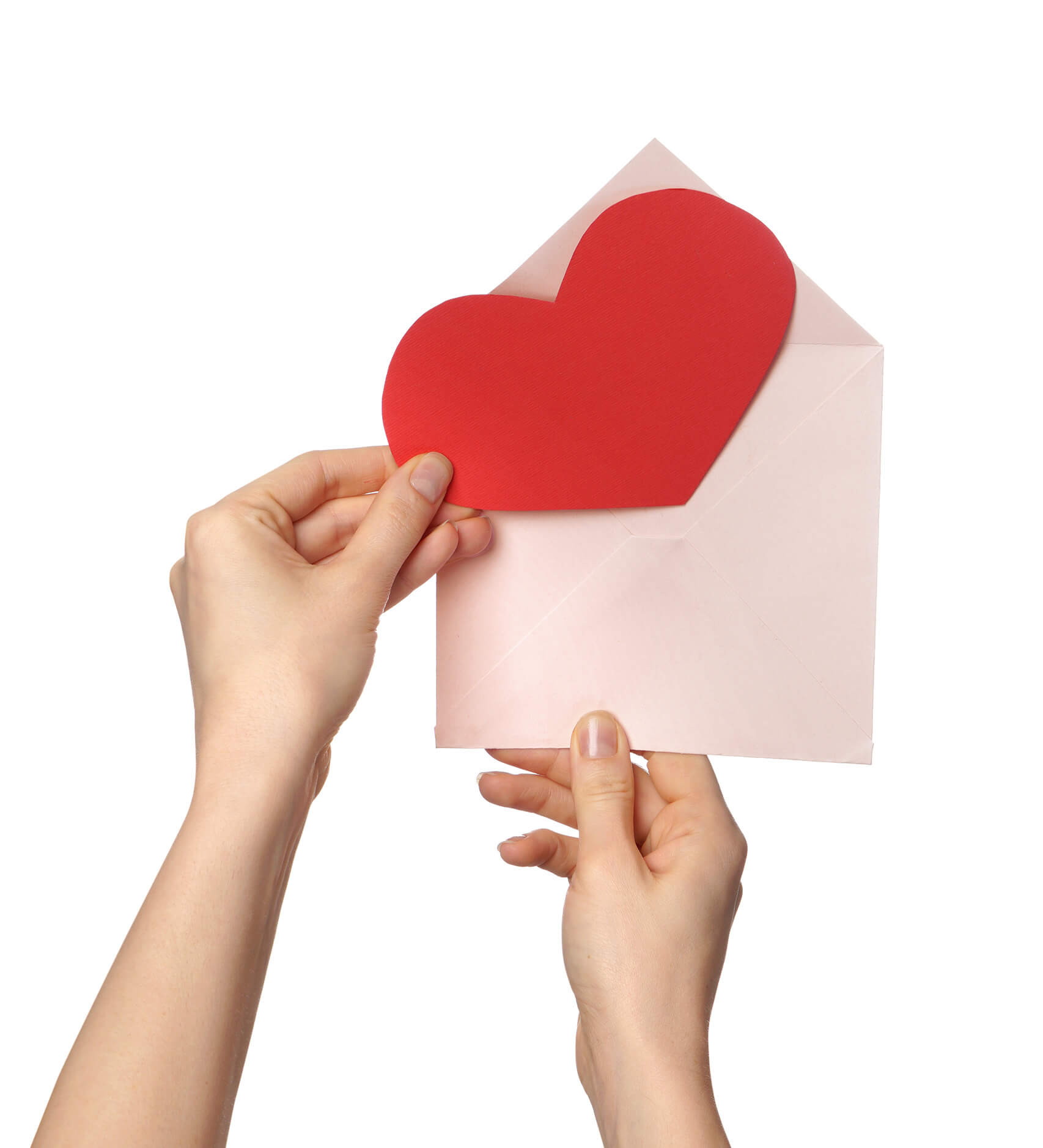 Deux mains tiennent une enveloppe blanche dans laquelle une carte en forme de coeur rouge s'apprête à être insérée.