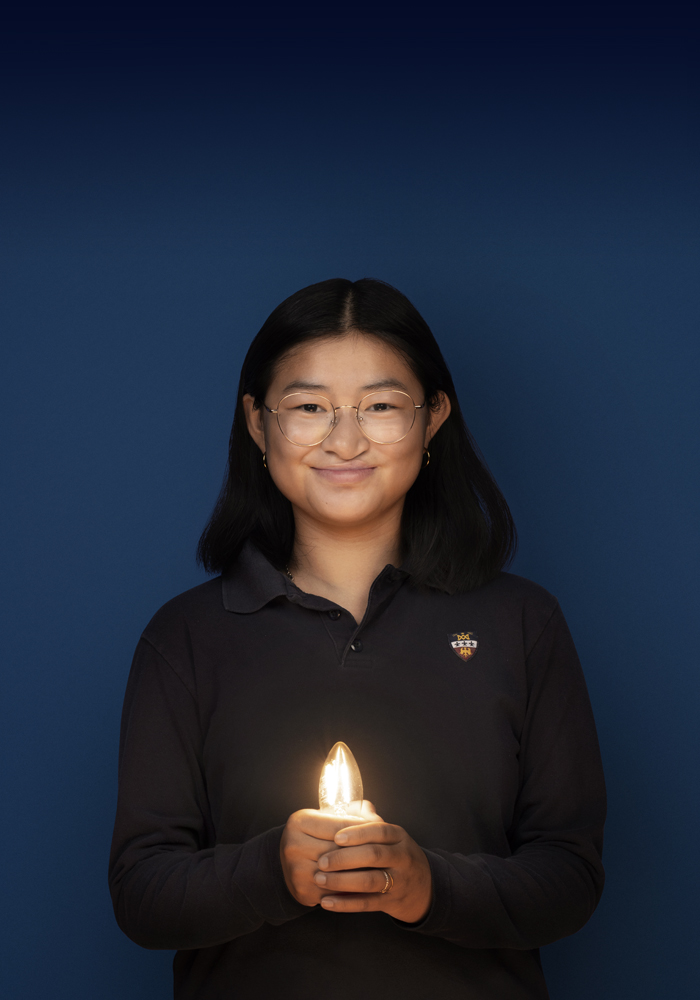 Ambassadeur de cette édition, sur fond foncé, avec une ampoule dans les mains éclairant son visage.