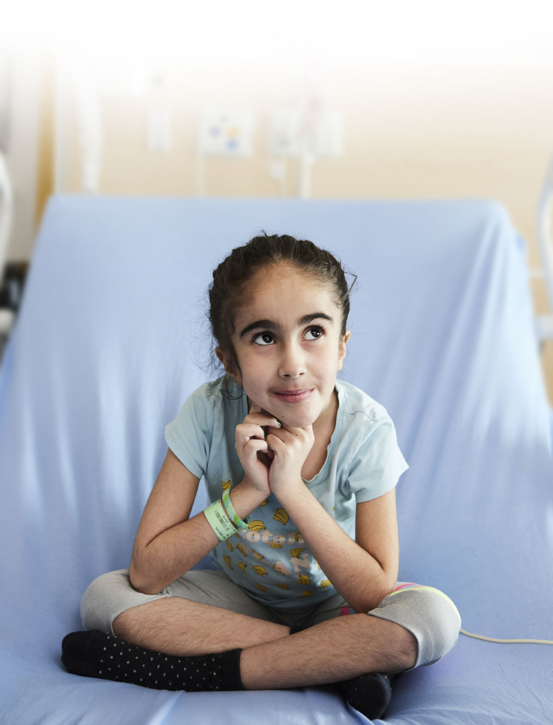 Eva, pensive et le regard porté vers le ciel, sur son lit d'hôpital à Sainte-Justine.